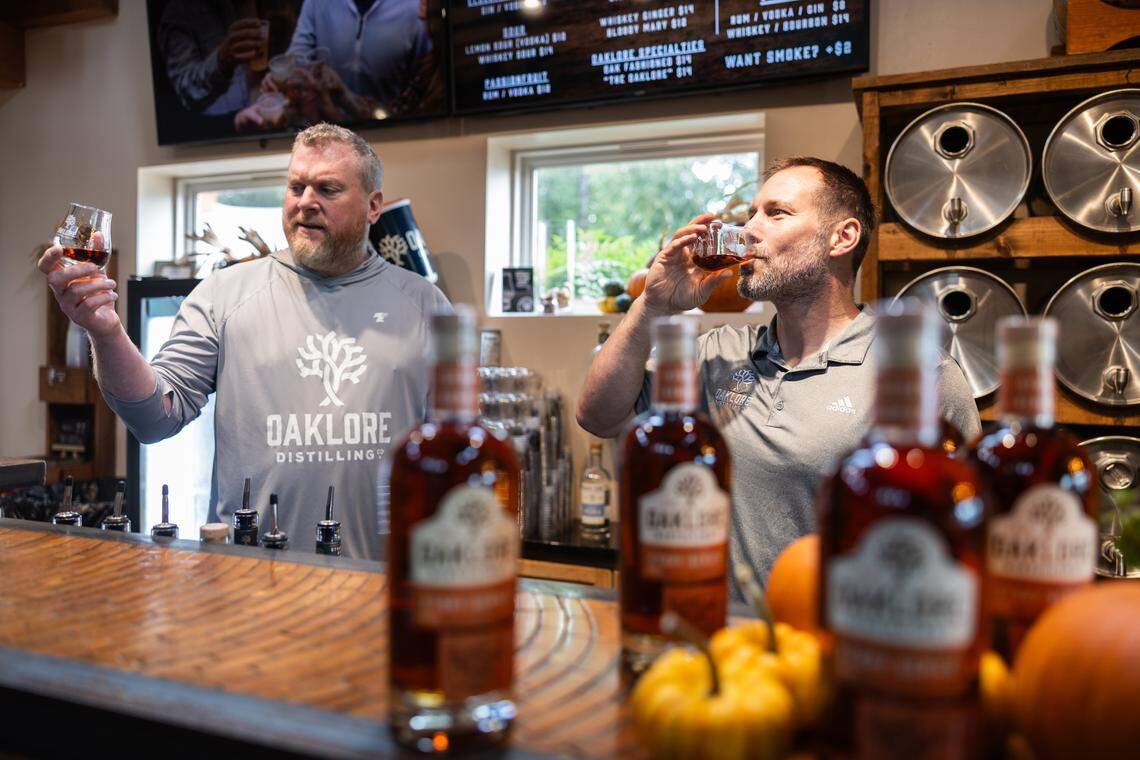 Matt Simpkins, left, and Tom Bogan sample a whiskey at Oaklore Distilling Co. in Matthews, N.C., on Tuesday, September 30, 2025.