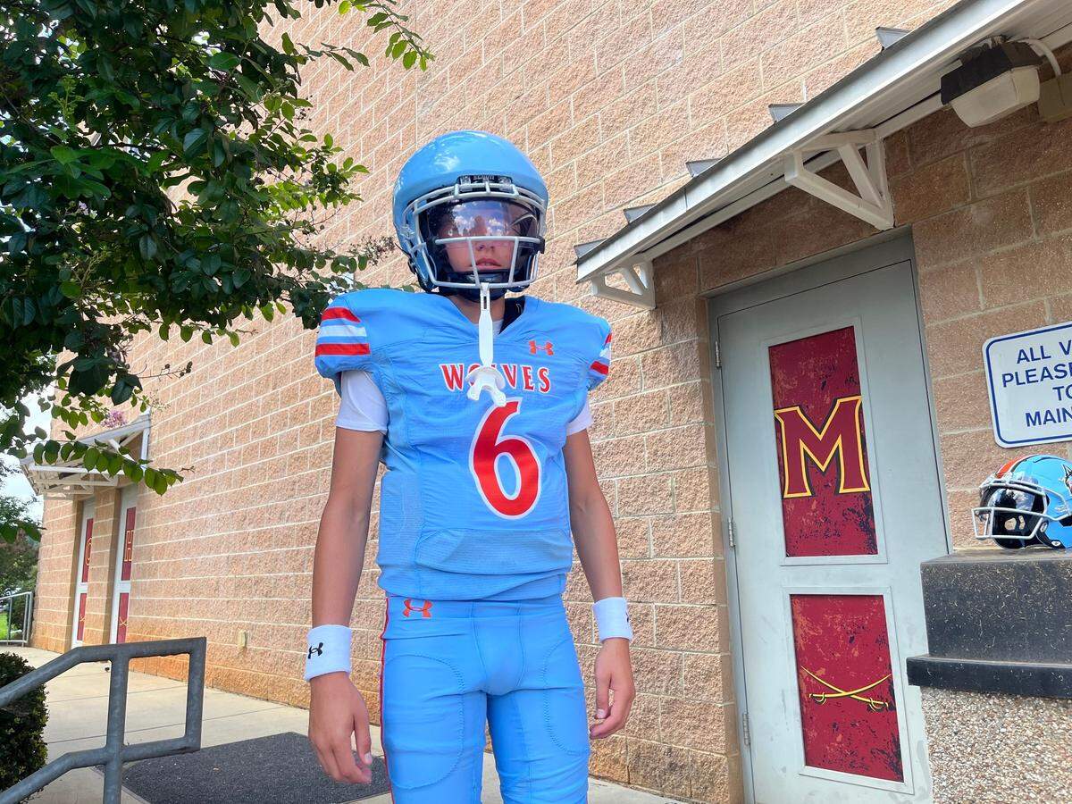 Ryder Polston, the quarterback at the new Ballantyne Ridge High School, poses in the Wolves’ home uniforms during a photoshoot at Community House Middle School in Charlotte, N.C.