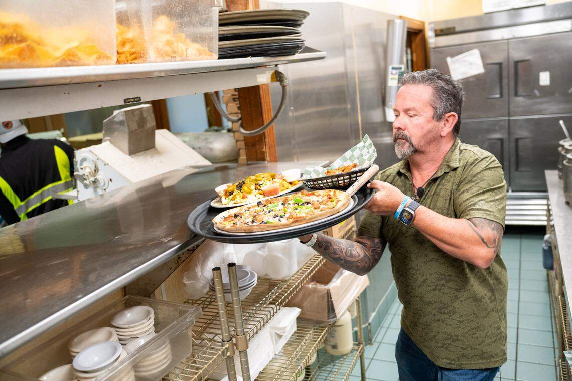 Kristophers owner Robby Stringer lifts a tray of food.