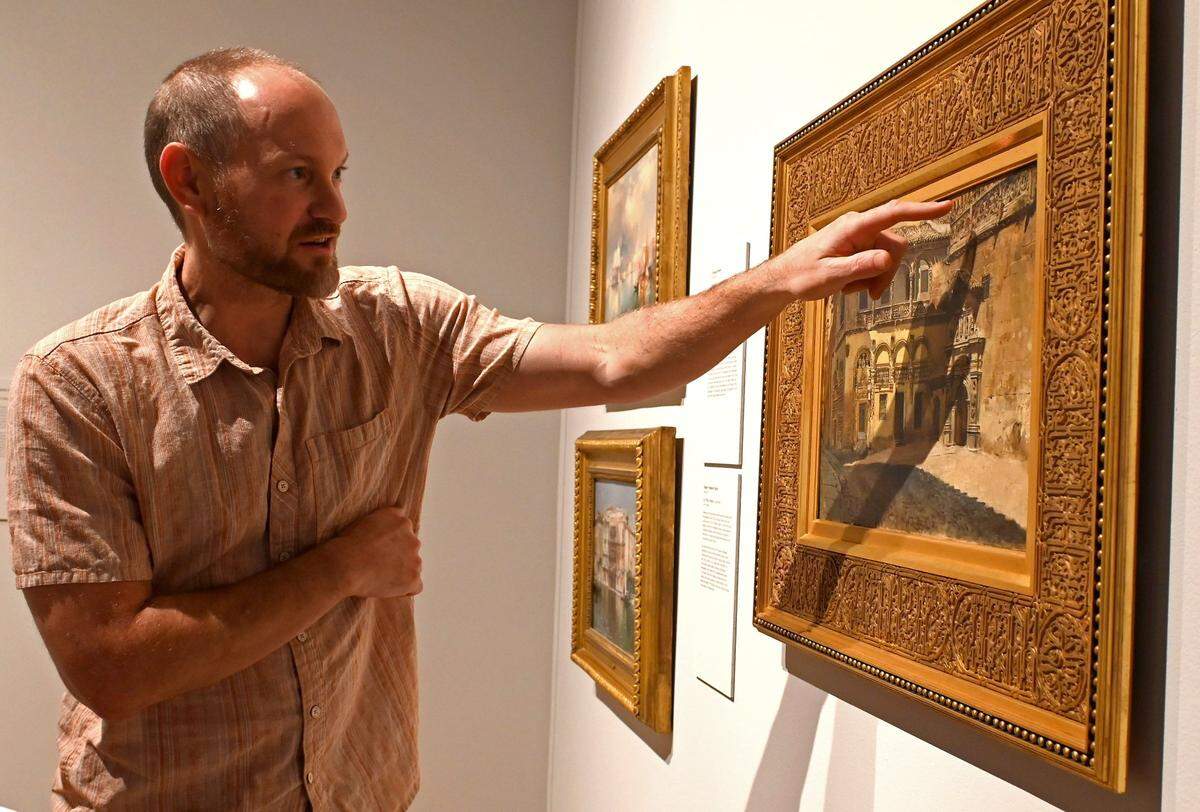 The Mint Museum’s senior curator of American art, Jonathan Stuhlman, discusses Edwin Lord Weeks’ ”Sacristy and Doorway of the Cathedral, Granada,” circa 1880. Diane Jacobsen searched for 14 years to find a 19th century American frame with an Arabic-inspired script ornamentation to match the painting’s Moorish-influenced architectural details.