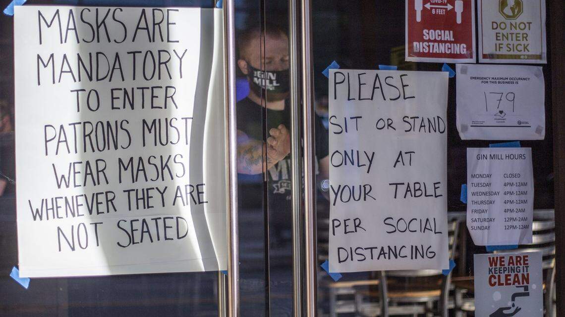 An employee of The Gin Mill steps outside on June 26, 2020. Gov. Cooper required residents to wear masks inside or when it is difficult to maintain a safe distance outside.
