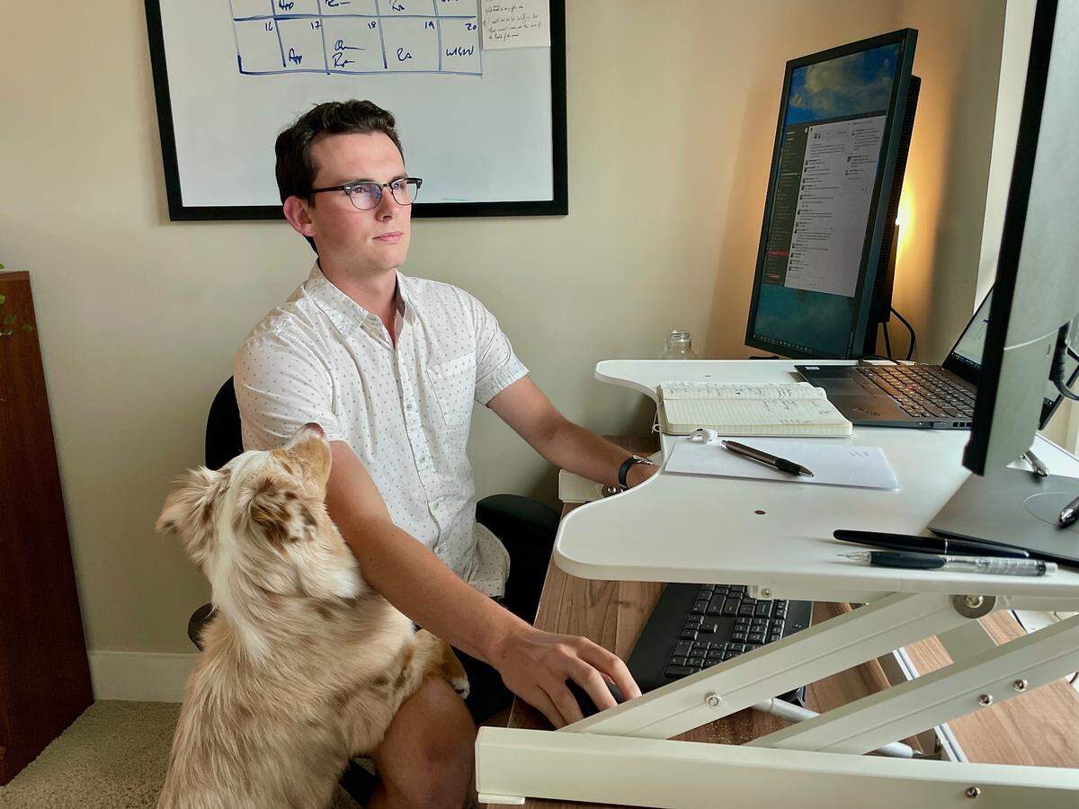 Blake Morgan works from his home in South End with dog Nutmeg nearby. Morgan was hired by Red Ventures in Fort Mill during the coronavirus pandemic and has not worked in the office.