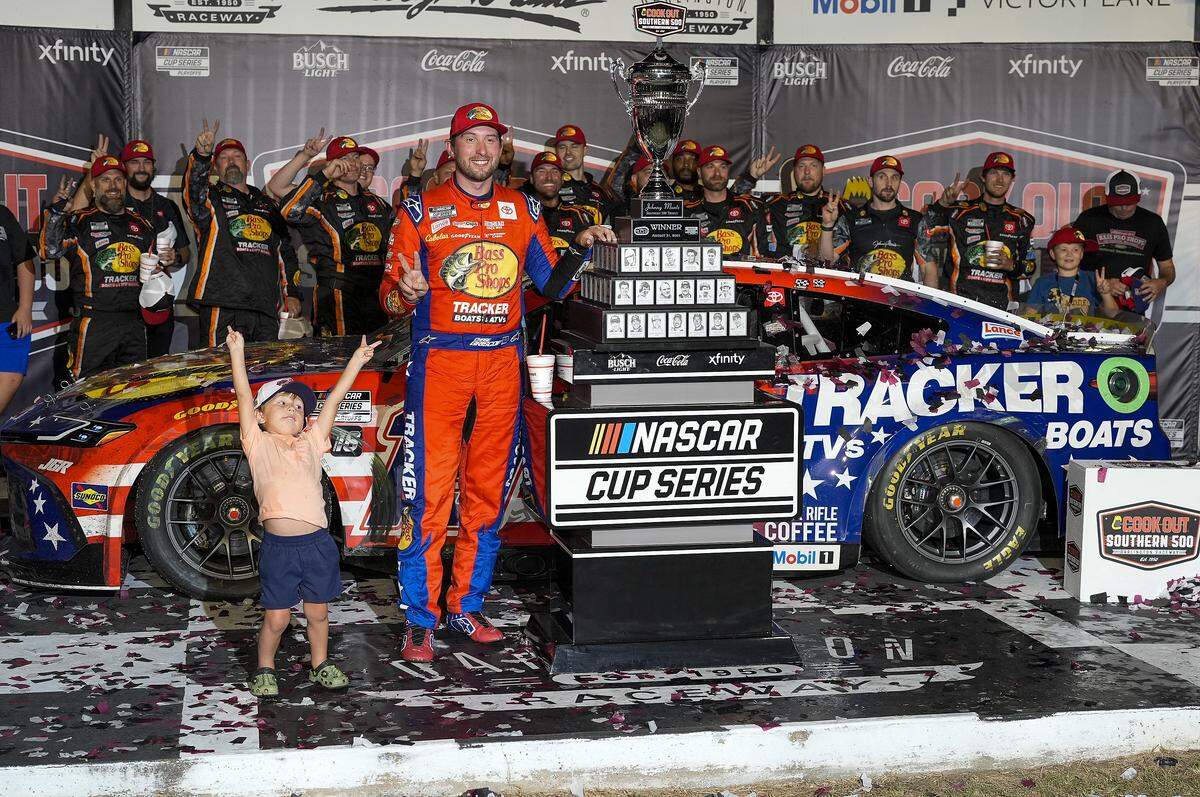 Aug 31, 2025; Darlington, South Carolina, USA; NASCAR Cup Series driver Chase Briscoe (19) celebrates his win with his son, Brooks, at the Cook Out Southern 500 at Darlington Raceway.