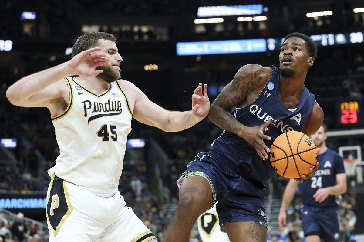 Avantae Parker (6) of Queens University drives to the basket against Oscar Cluff of Purdue during the teams’ NCAA Men’s Basketball Tournament first-round game at Enterprise Center on March 20, 2026 in St Louis, Missouri.