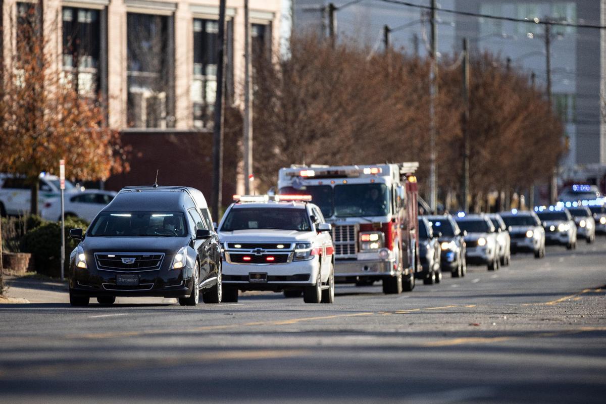 Dozens of police and emergency vehicles follow the hearse carrying the body of Charlotte-Mecklenburg police Officer Mia Goodwin to Alexander Funeral Home on Statesville Avenue in Charlotte, N.C., on Thursday, December 23, 2021.
