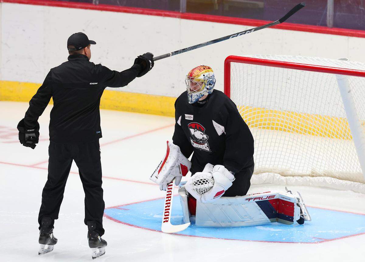 Charlotte Checkers goalie Cooper Black, right, receives instructions from a coach during practice at BoJangles Coliseum in Charlotte, NC on Thursday, October 9, 2025.