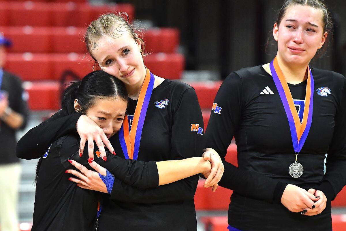 Marvin Ridge’s Ashley Murray (8) and Clarisse Tedjo (9) embrace, and Kiley Petras (7) react after losing the 2024NCHSAA 4A Championship to Cardinal Gibbons. The Marvin Ridge Mavericks took on the Cardinal Gibbons Crusaders in the NCHSAA 4A Volleyball Championship match in Raleigh, N.C. on November 2, 2024.