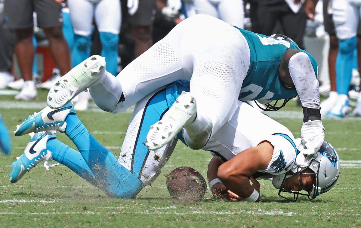 Carolina Panthers quarterback Bryce Young fumbles the ball on a run as Jacksonville Jaguars linebacker Foyesade Oluokun makes the hit on Sunday, September 7, 2025 at Everbank Stadium in Jacksonville, Florida.