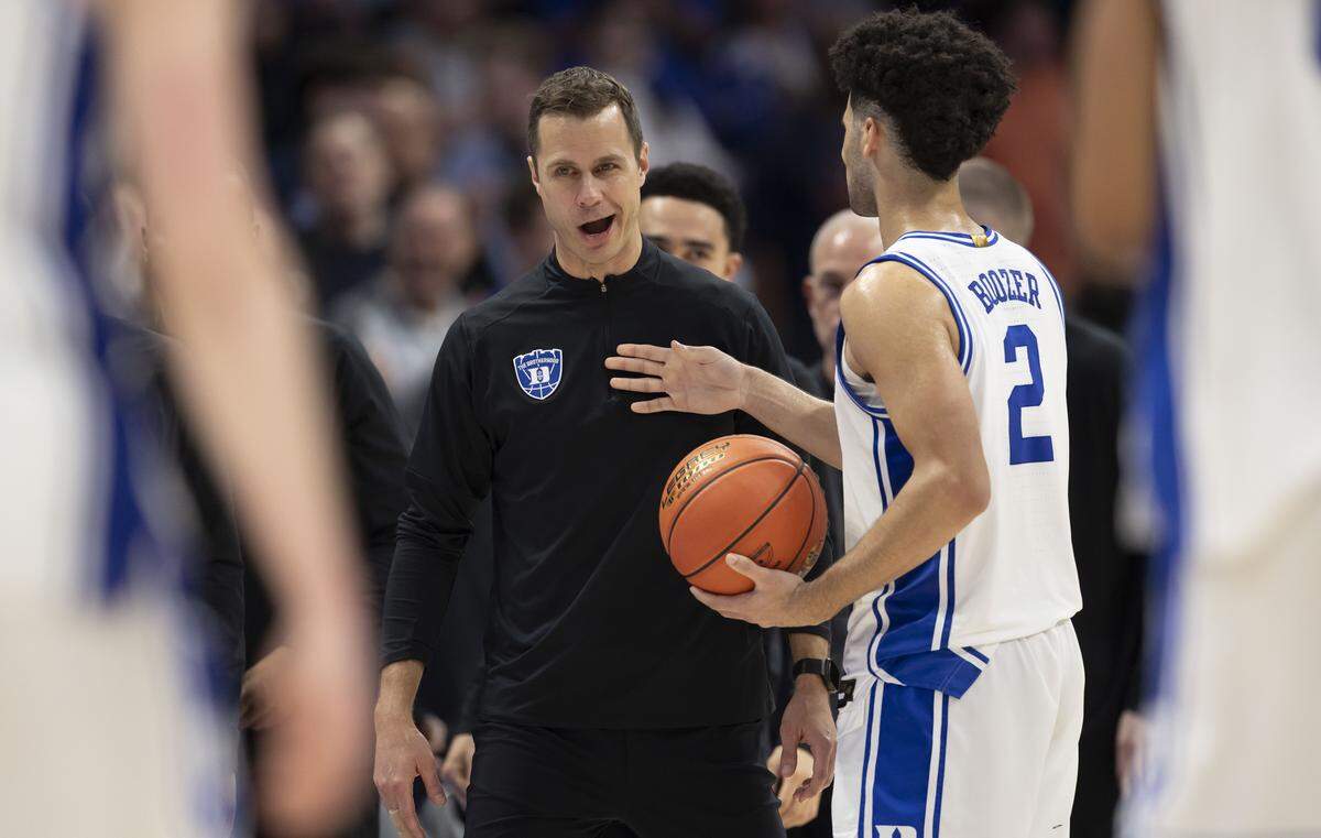 Duke coach Jon Scheyer smiles as he speaks to guard Cayden Boozer (2) as time expires in the Blue Devils’ 73-61 victory over Clemson on Friday, March 13, 2026, during the semifinals of the ACC Tournament at Spectrum Center in Charlotte, N.C.