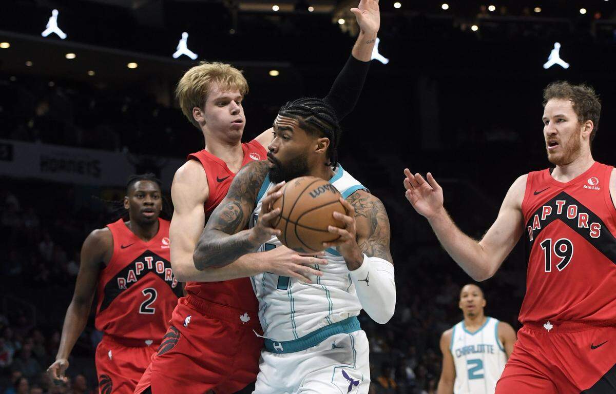 Charlotte Hornets center Nick Richards (4) drives past Toront Raptors guard forward Gradey Dick (1) during the first half at the Spectrum Center.