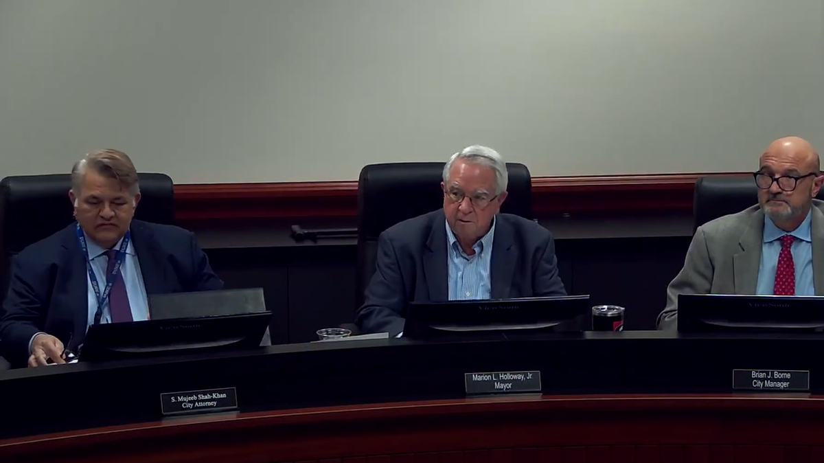 Monroe Mayor Marion Holloway sits between former Monroe city attorney S. Mujeeb Shah-Khan and former city manager Brian Borne at a city council meeting Feb. 14, 2022.