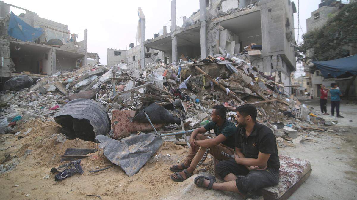 Palestinians isit by the rubble Abu Helal family in Rafah refugee camp, Gaza Strip, Monday, Oct. 9, 2023. The strike killed dozens of people.(AP Photo/Hatem Ali)