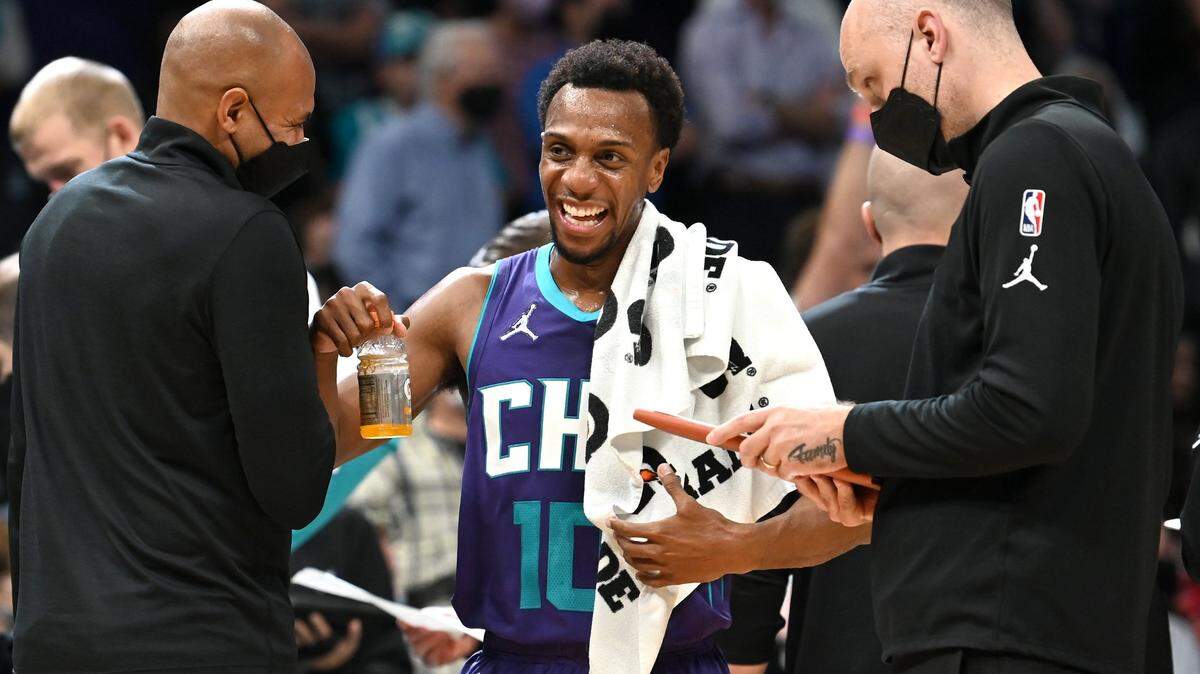 Charlotte Hornets guard Ish Smith, center, laughs with an assistant coach along the team bench during second half action against the Boston Celtics at Spectrum Center in Charlotte, NC on Monday, October 25, 2021.