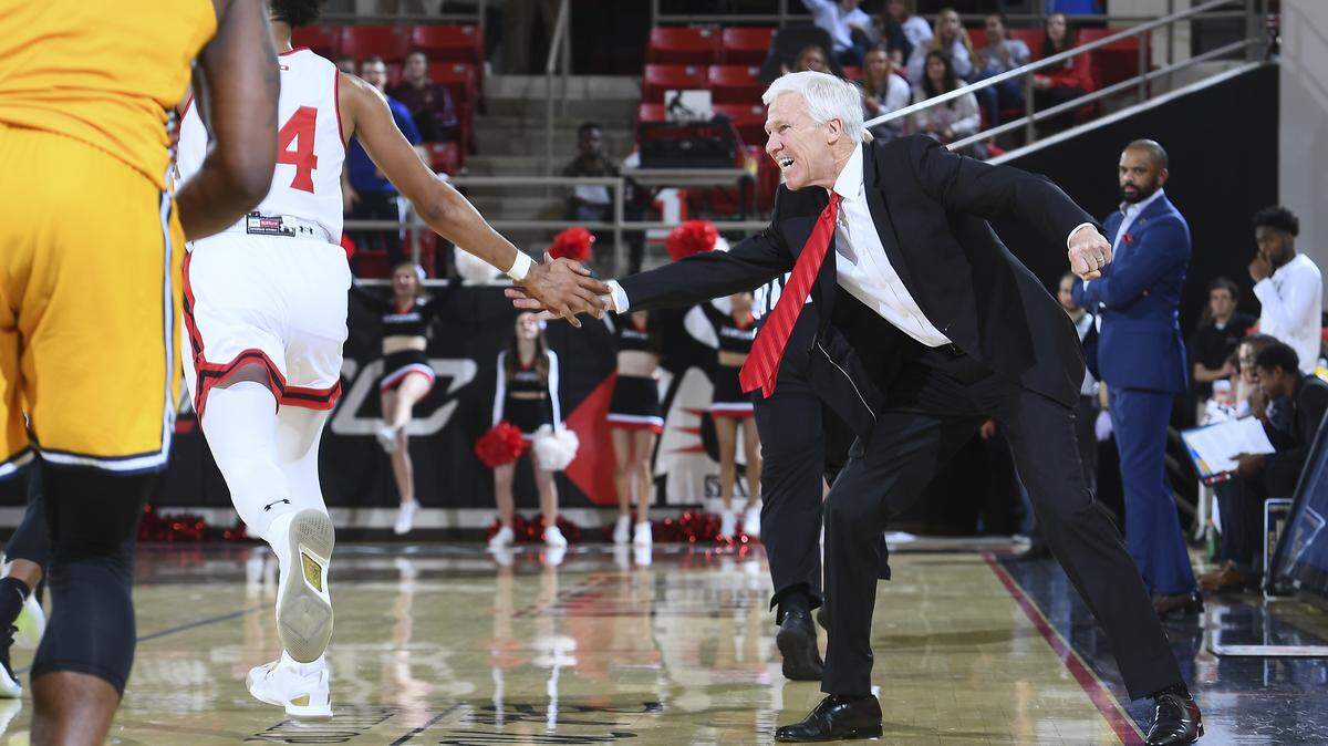 Davidson coach Bob McKillop gives guard Carter Collins (left) encouragement as Coppin State coach Juan Dixon (background) looks on.