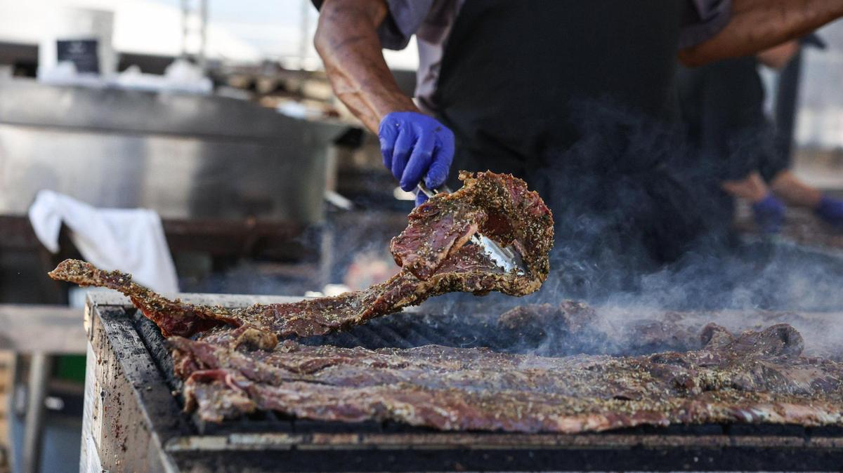 Ed Turner flips skirt steaks on a grill in preparation for the PGA Championship at Quail Hollow Country Club in Charlotte, NC this week.