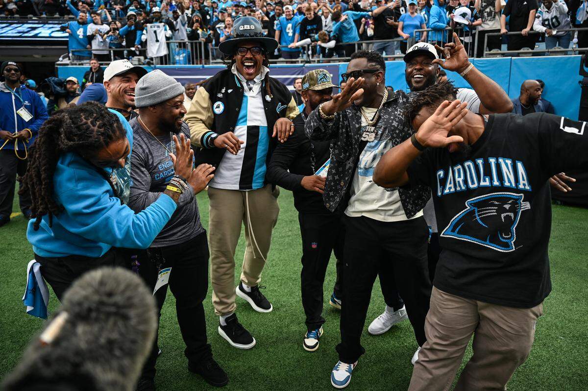 Cam Newton, at center, is joined by fellow former members of the Panthers’ 2015 Super Bowl team after he pounded the drum before Saturday’s playoff game in Charlotte.