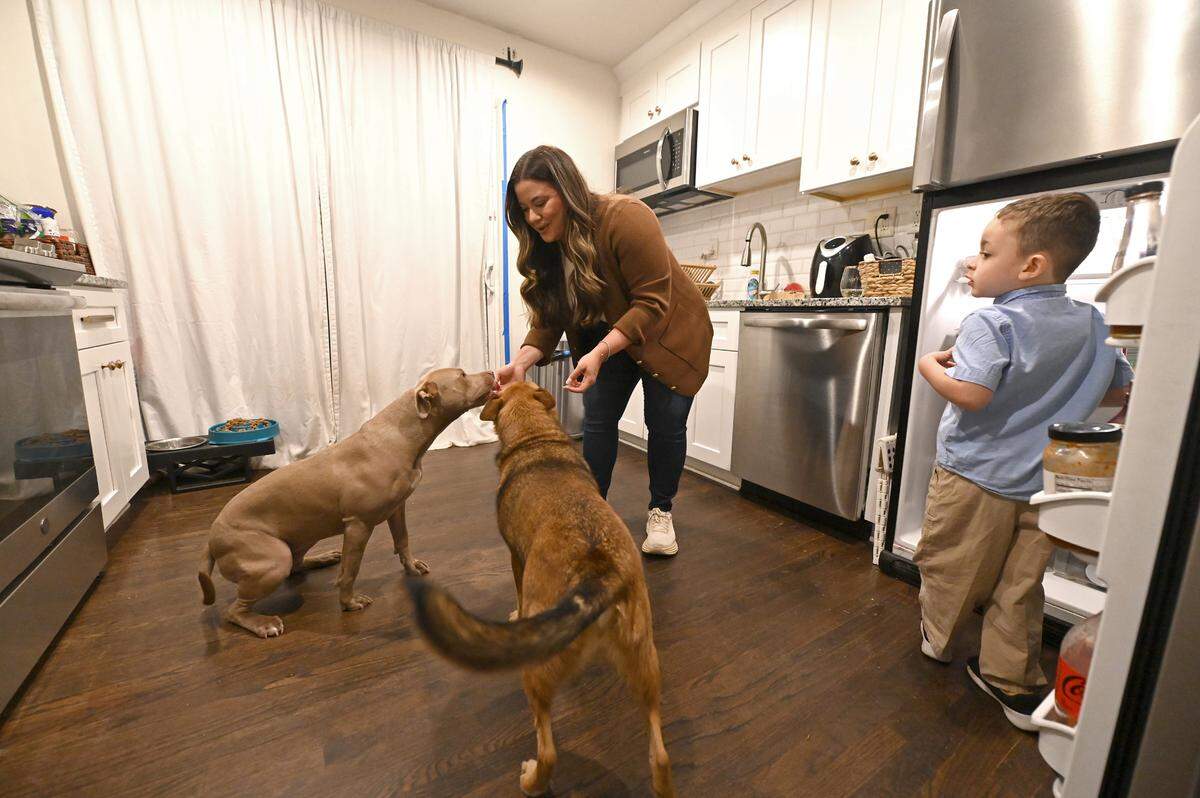 Liz Monterrey gives Jade, left, and Zoey, right, a snack as her son, Isaac, watches.