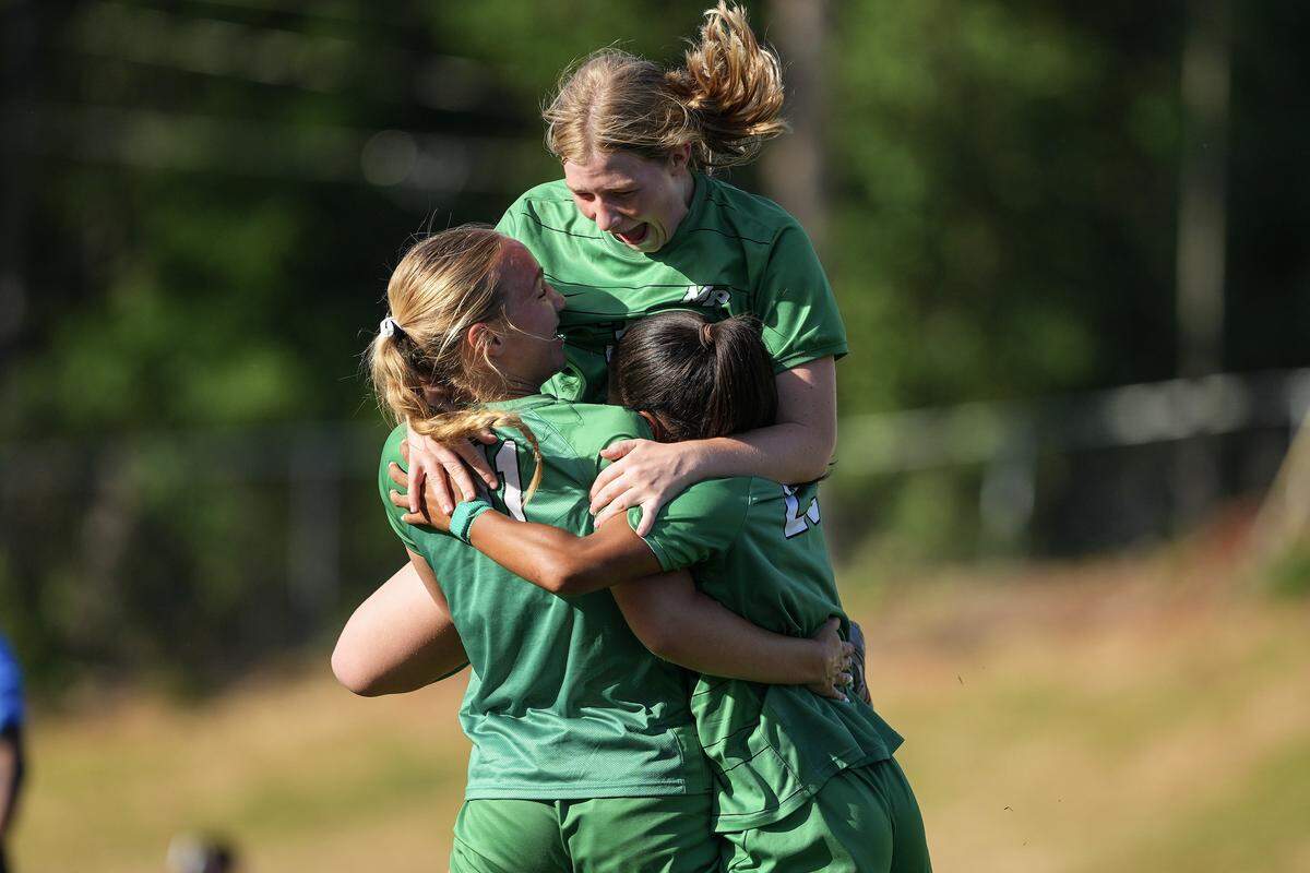 Myers Park’s Cailin Whitlock (11) celebrates with Amaya Falzarano (23) and Anne Healy Perry (30) after scoring a goal during the first half of a NCHSAA girls playoff soccer match against Northwest Guilford, Monday, May 18, 2026, in Charlotte, N.C. 