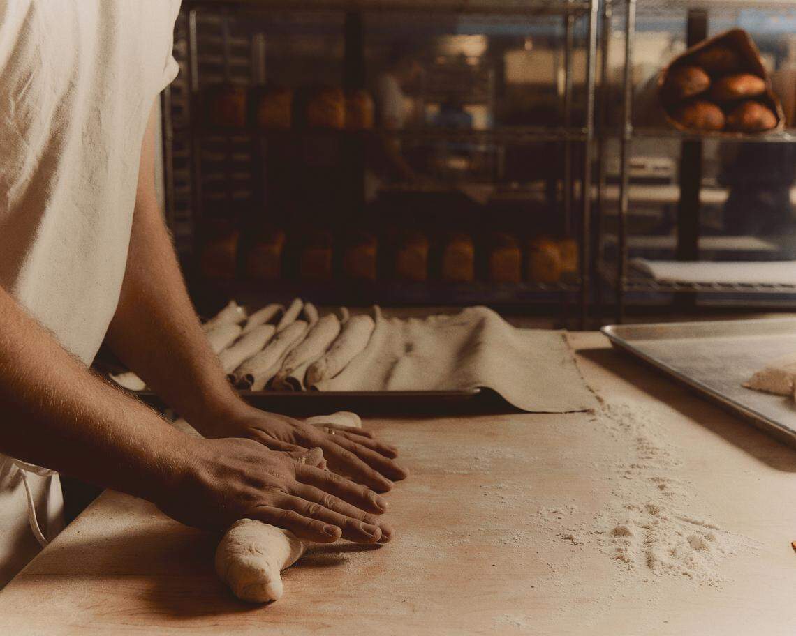 Cutting into a loaf of sourdough bread at Verdant.