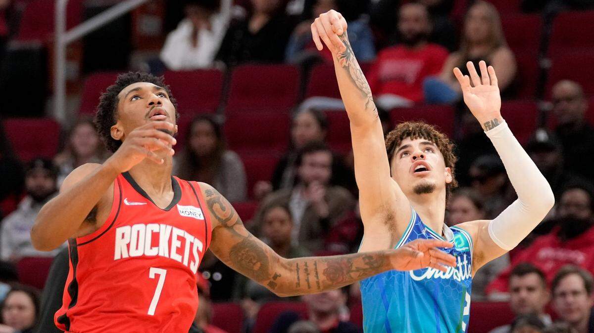 Charlotte Hornets guard LaMelo Ball, right, watches his three point basket as Houston Rockets guard Armoni Brooks (7) defends during the first half of an NBA basketball game, Saturday, Nov. 27, 2021, in Houston. (AP Photo/Eric Christian Smith)