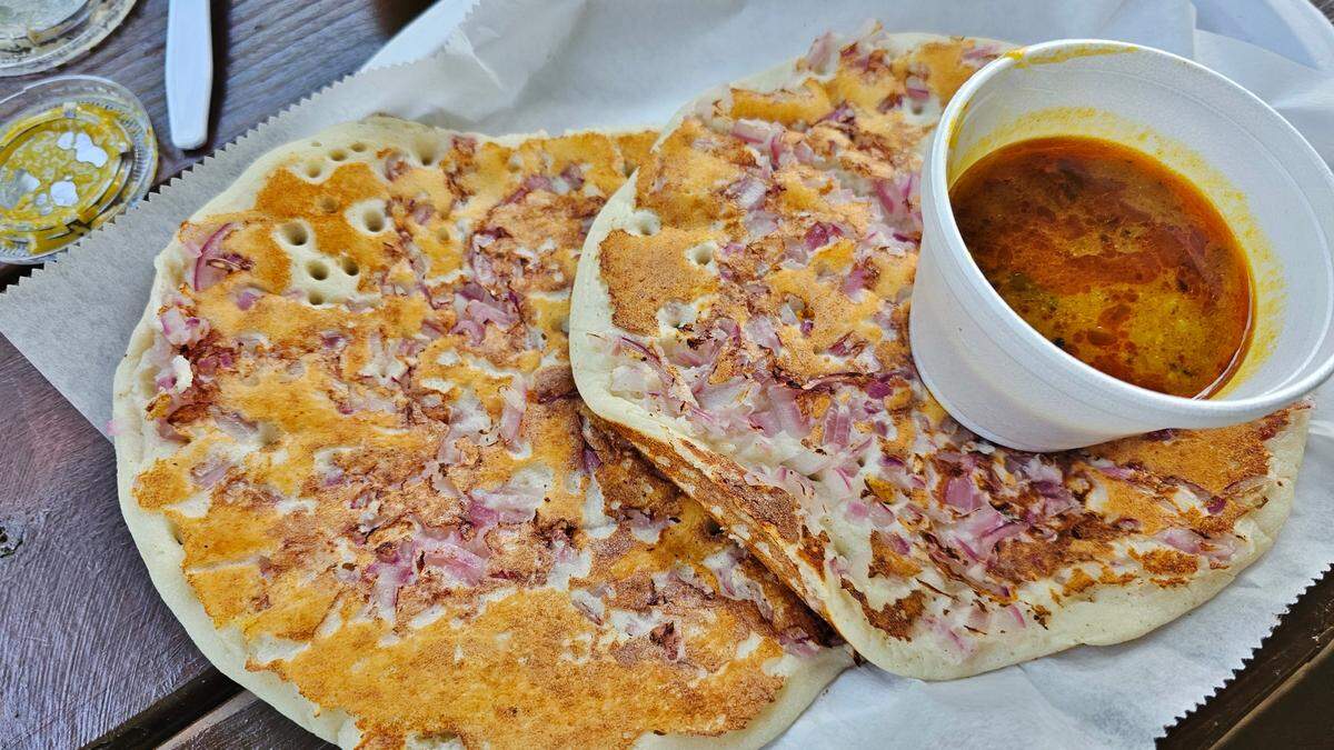 Onion uttapam served with broth at Triveni Supermarket.