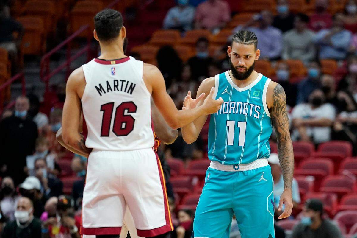 Twin brothers Miami Heat forward Caleb Martin (16) and Charlotte Hornets forward Cody Martin (11) shake hands before Monday’s preseason game. The Martin Twins played together in Charlotte the past two seasons.