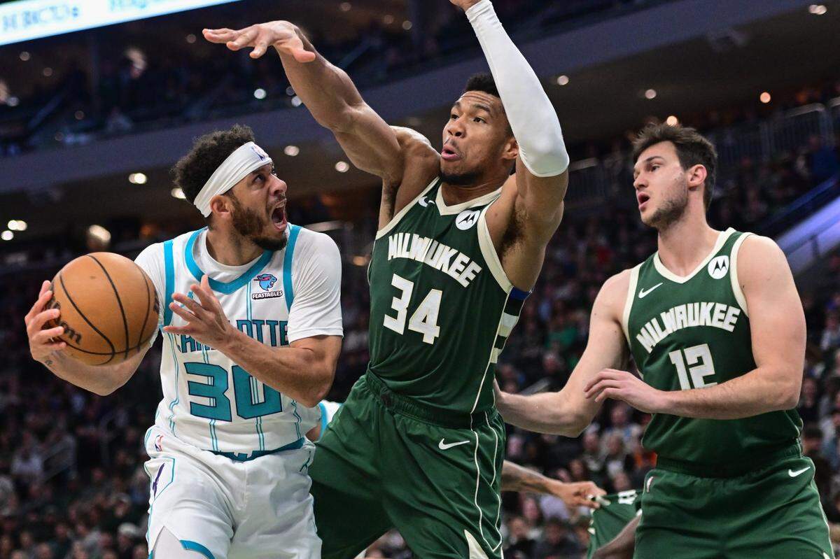 Charlotte Hornets guard Seth Curry (30) looks for a shot against Milwaukee Bucks forward Giannis Antetokounmpo (34) and  forward Danilo Gallinari (12) in the second quarter at Fiserv Forum.