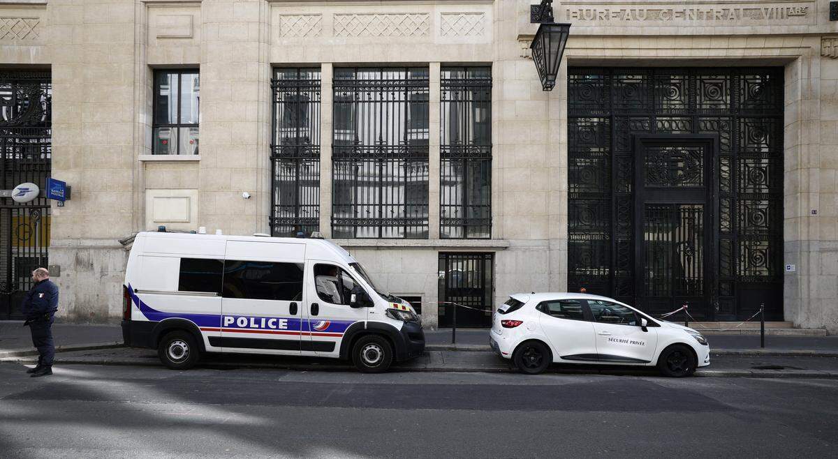 A policeman stands alongside police and private security vehicles outside The Bank of America building in the 8th arrondissement of Paris on March 28, 2026, following an apparent bomb attack attempt. French police stopped an apparent bomb attack outside a US bank in Paris early March 28, 2026, when they arrested a man about to set off a homemade explosive device, sources close to the case told AFP. The incident occurred around 3:30 am (0130 GMT) in front of a Bank of America building in the chic 8th arrondissement, a couple of streets from the Champs-Elysees. (Photo by Sebastien DUPUY / AFP via Getty Images)
