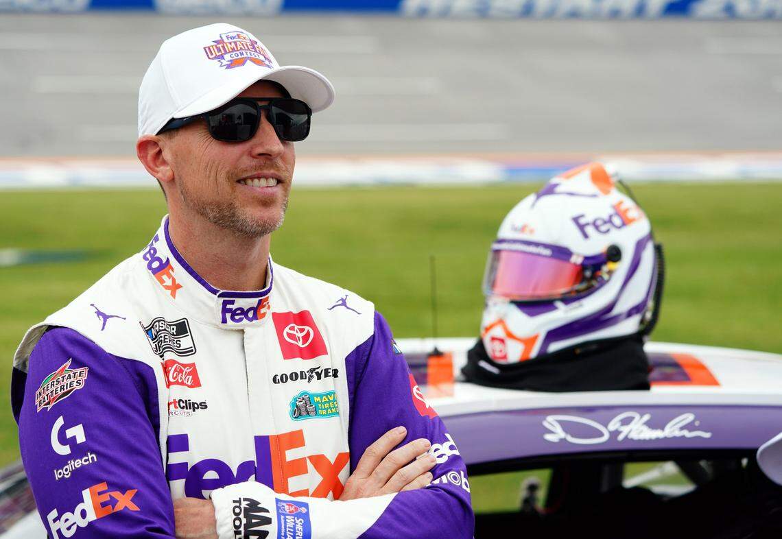 Apr 20, 2024; Talladega, Alabama, USA; NASCAR Cup Series driver Denny Hamlin (11) waits by his car on pit road during qualifying for the Geico 500 at Talladega Superspeedway.