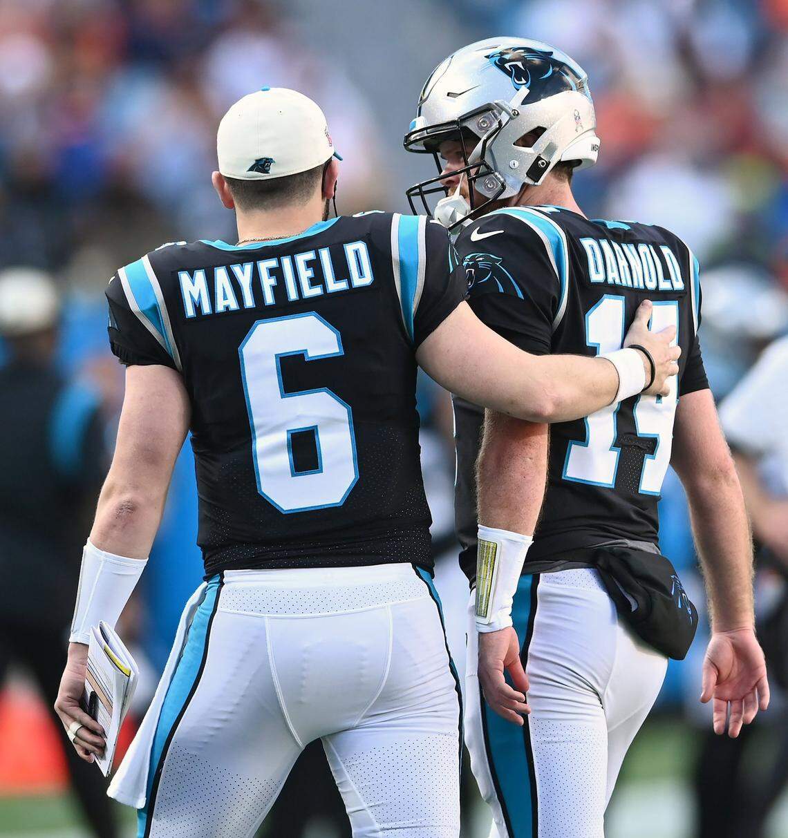 Carolina Panthers quarterback Baker Mayfield (left)and Sam Darnold talk during a game in 2022.