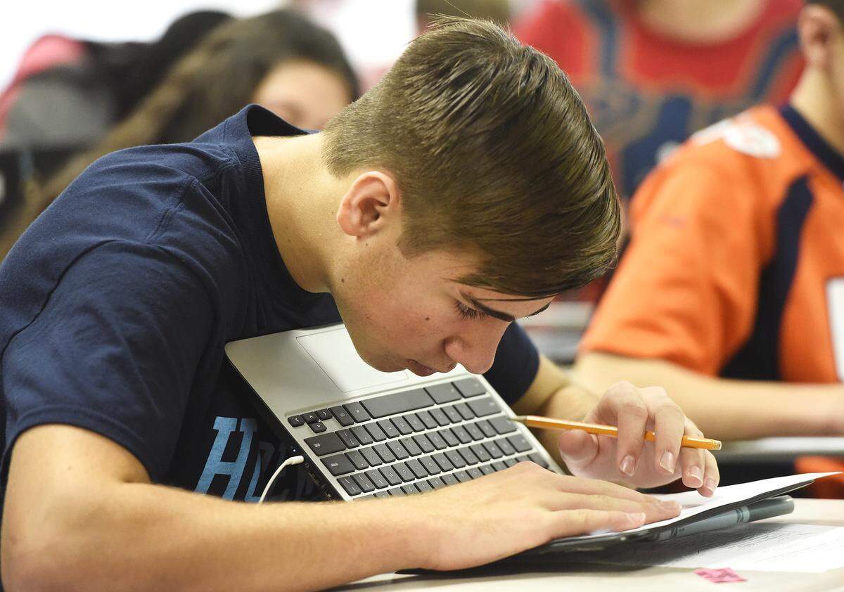 Jackson Scullion, 14, works on a project about Romeo and Juliet in a Cambridge English class at Hopewell High School. Students at the Huntersville public school get the same challenging courses as students in 160 countries that participate in the program.