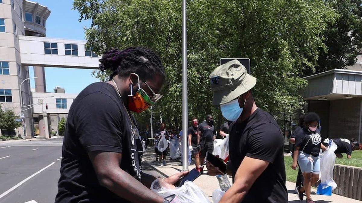 Atlanta Falcons guard Jamon Brown and Carolina Panthers running back Reggie Bonnafon helping clean up Louisville following protests. (Courtesy of Total 360 Management)