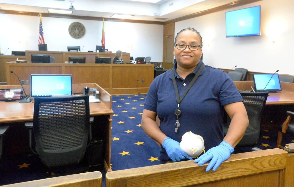 Georgette Charles, cleaning supervisor at the federal courthouse in Charlotte, inside one of the courtrooms on Friday, April 10, 2020. Charles disinfects the courtrooms before, between, and after sessions during the day. The Western District of North Carolina, with main courthouses in Charlotte and Asheville, is the only federal judicial circuit in the country cleaning before and after all court activity.
