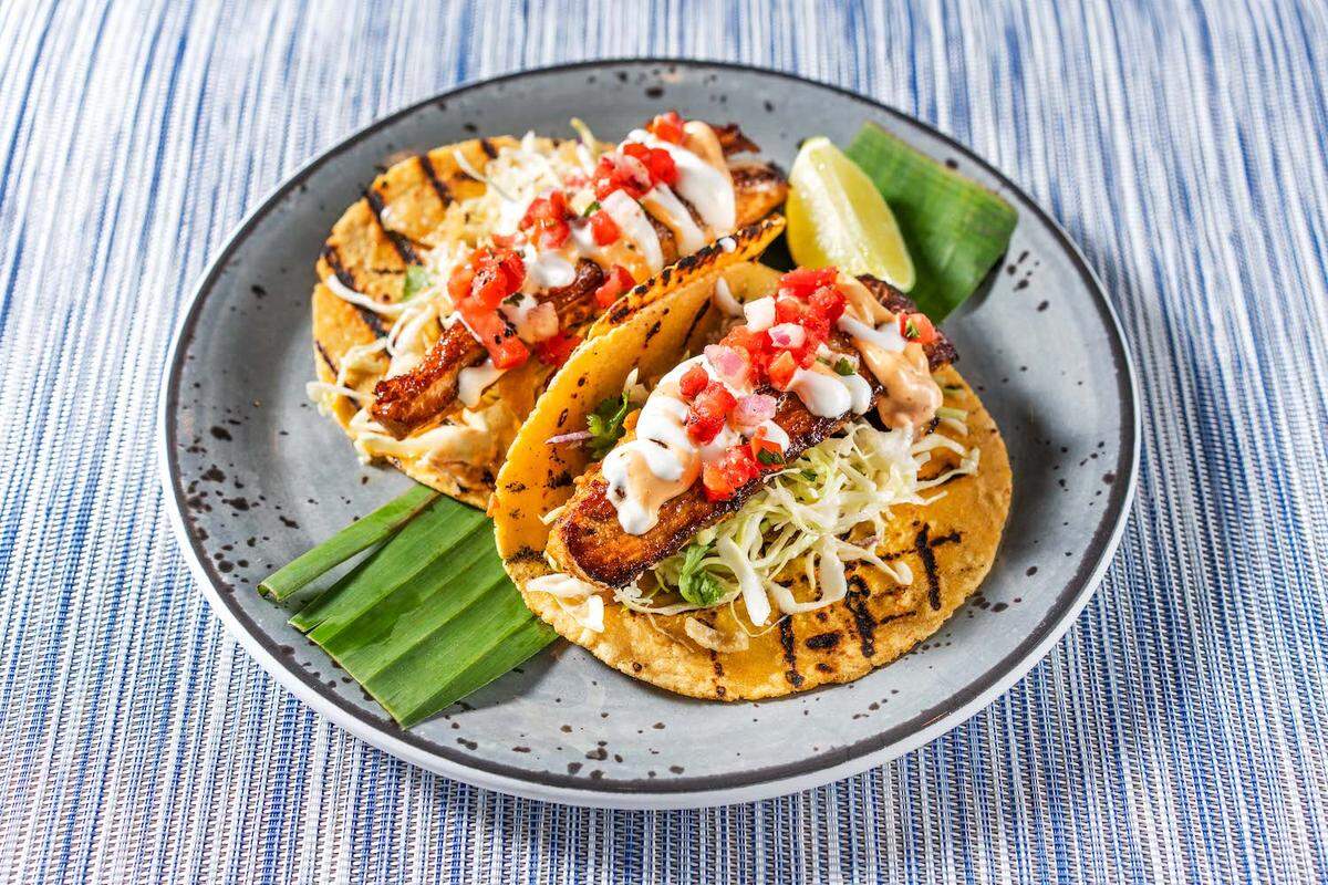 Tommy Bahama Marlin Bar’s Blackened Mahi Tacos come with tomato relish, chipotle aioli, island slaw and lime sour cream. A gluten-free option is available, served on a lettuce wrap.