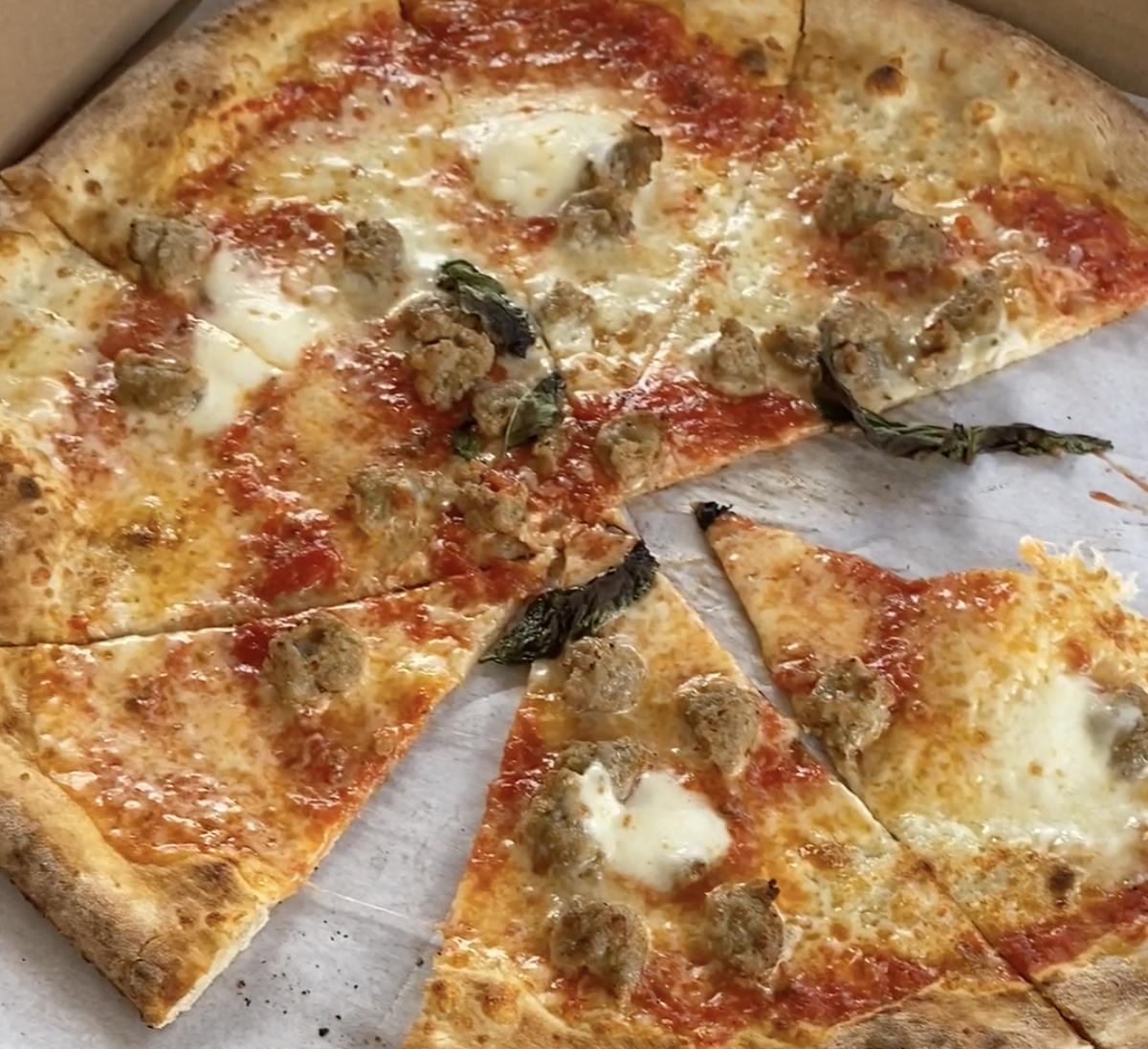 A Toscana pizza from Alino is topped with sausage, San Marzano tomato sauce, fresh buffalo mozzarella, fresh basil and fresh garlic.