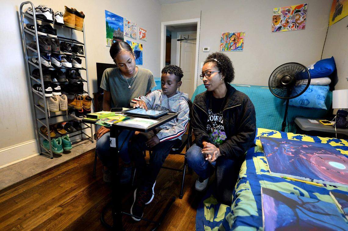 Daniel Feaster, center, works on a school lesson as his sister, D’erra Moise, left and mother Devonne Moise, right, watch on Monday, August 17, 2020. Daniel a second grader at Renaissance West Stem Academy is doing remote learning from the family’s home.