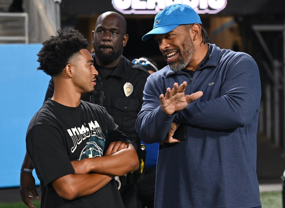 Carolina Panthers quarterback Bryce Young, left and former defensive end and Hall of Famer Julius Peppers, right, talk along the sideline at Bank of America Stadium during the Weddington vs Providence Day football game on Thursday, August 22, 2024.