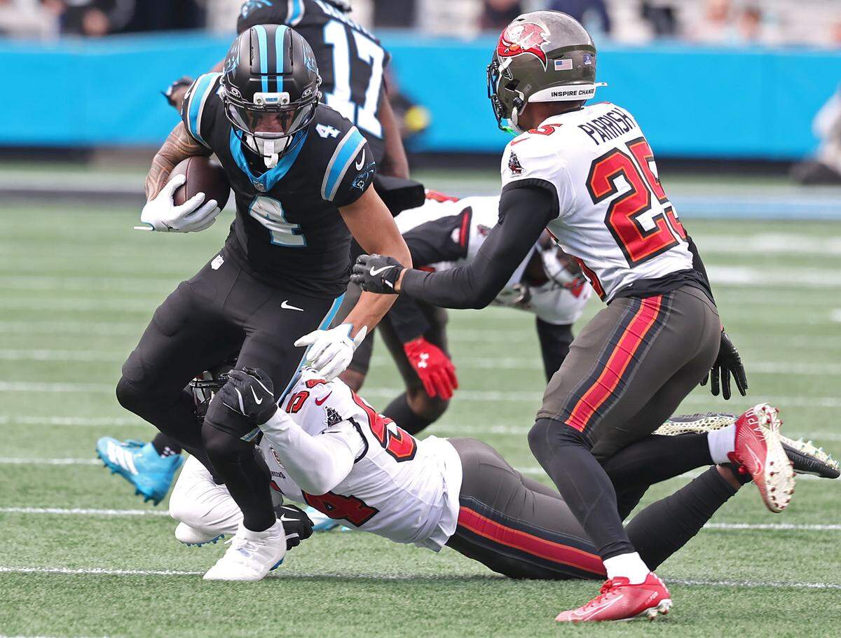 Carolina Panthers wide receiver Tetairoa McMillan, left, turns to pick up yardage following a pass reception as Tampa Bay Buccaneers defenders look to make the tackle during action on Sunday at Bank of America Stadium. The Panthers defeated the Buccaneers 23-20. 