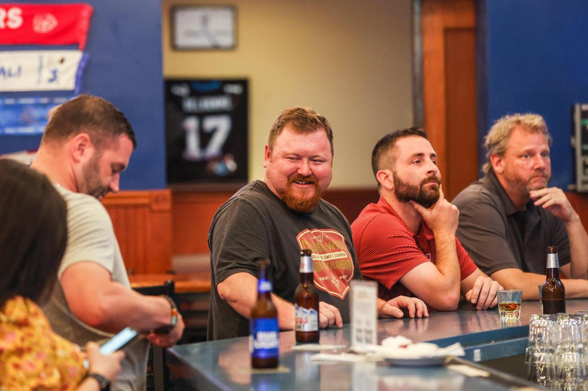 Patrons converse with one another at the bar of Dilworth Neighborhood Grille on Monday, August 1, 2022 in Spartanburg, SC.