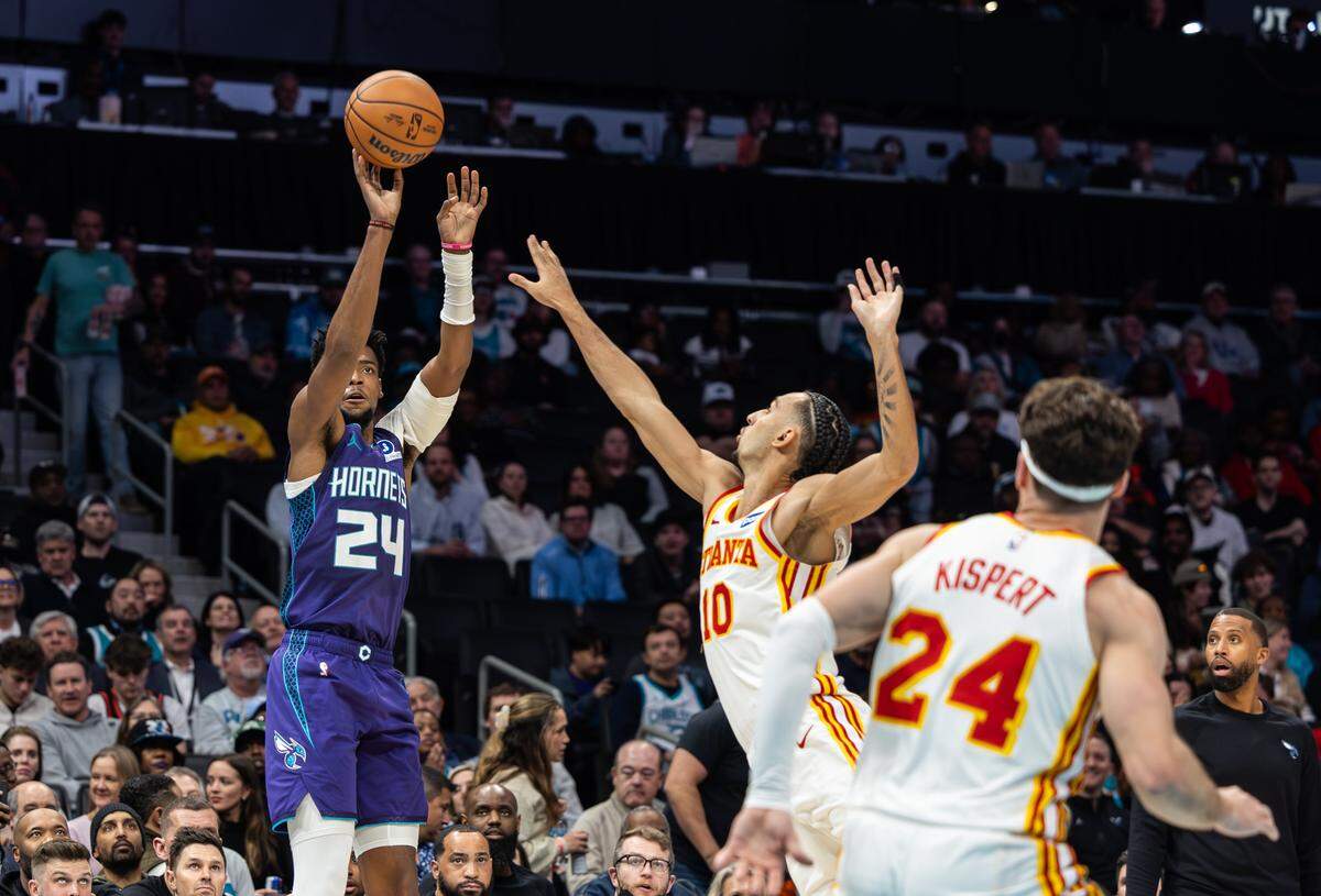 Charlotte Hornets forward Brandon Miller, left, shoots past Atlanta Hawks forward Zaccharie Risacher at the Spectrum Center in Charlotte, N.C., on Wednesday, February 11, 2026.