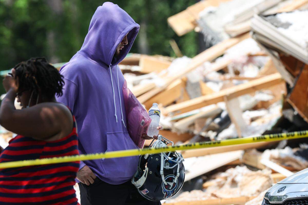 Titans cornerback Caleb Farley carries his helmet as he walks outside his house that sustained an explosion around 11:52pm last night on the 280 block of Barber Loop Road. Mooresville firefighters found one person dead in the 25-foot pile of rubble.