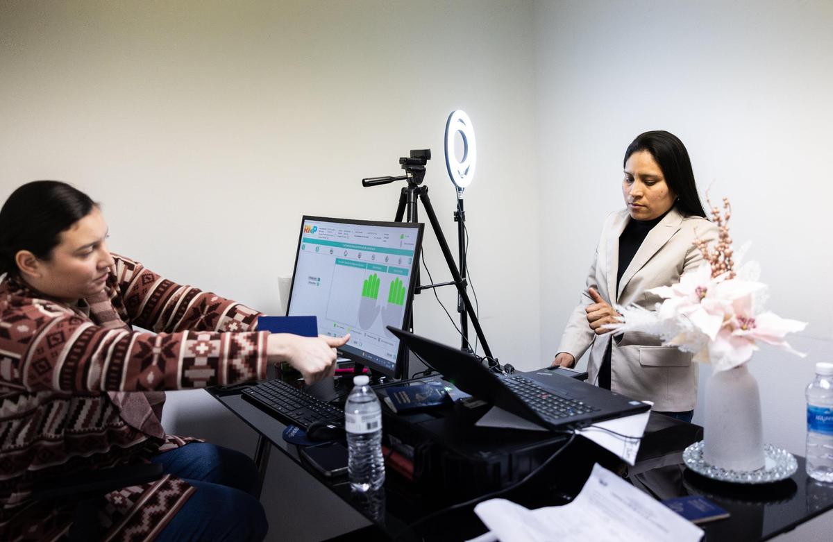 A woman gets her fingerprints taken in order to get a Honduran passport at the Honduran Consulate in Charlotte on Friday. Honduras’ consul general based in Charlotte says more Hondurans are trying to get their kids citizenship in Honduras after Trump returned to office, and that some are returning home.