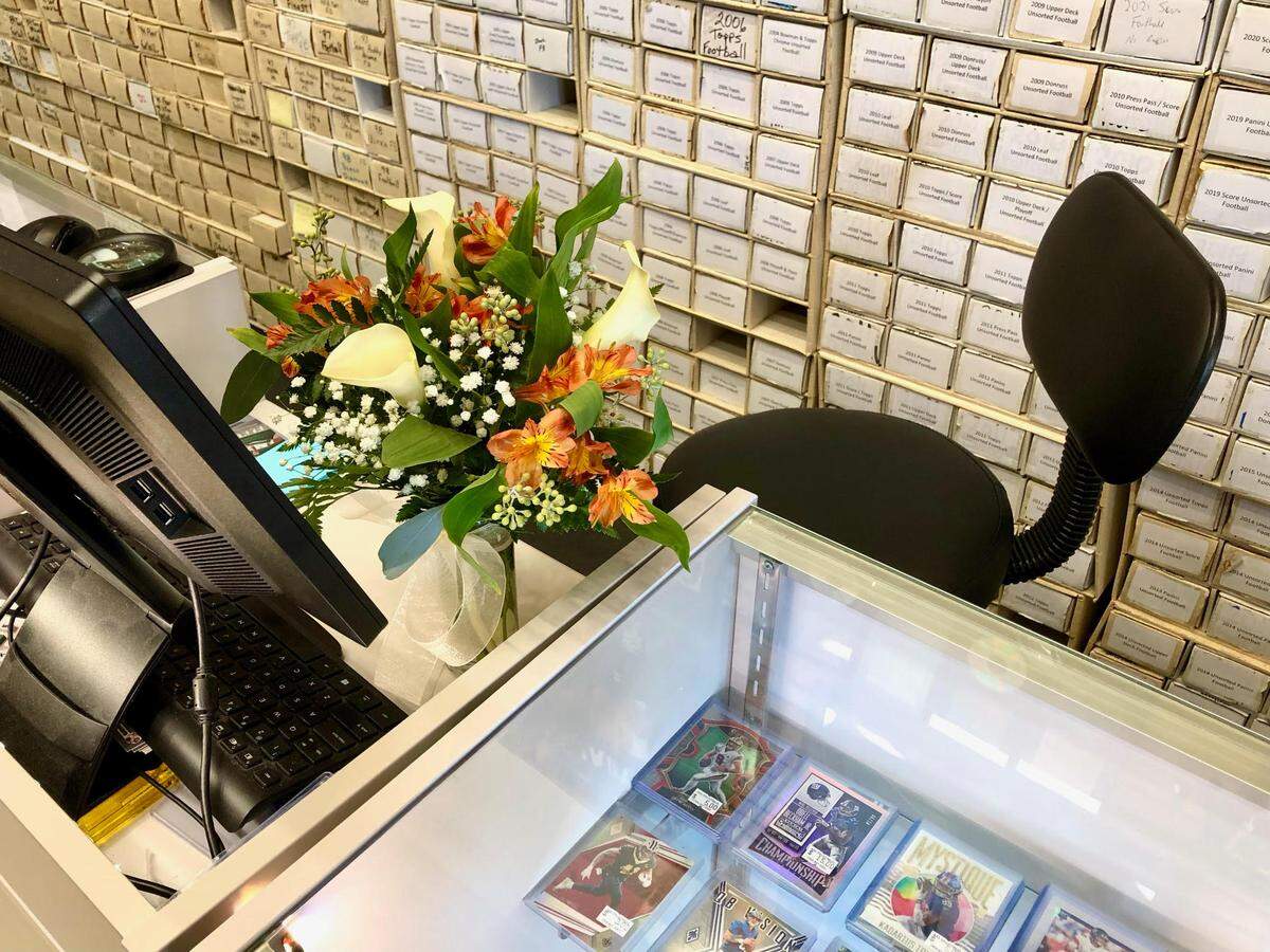 A bouquet of flowers sits at Jimmy Freiberg’s desk at AAA Collectibles in Matthews, NC. Freiberg was struck and killed by a bullet inside his apartment during a shootout in the parking lot at Horizons at Steele Creek on Saturday, March 5, 2022. Freiberg had served four years in the United States Marine Corp, was a disc jockey known as DJ Jazzy Jimmy, a general manager for several uptown establishments, a Realtor and manager at AAA Collectibles in Matthews, NC.
