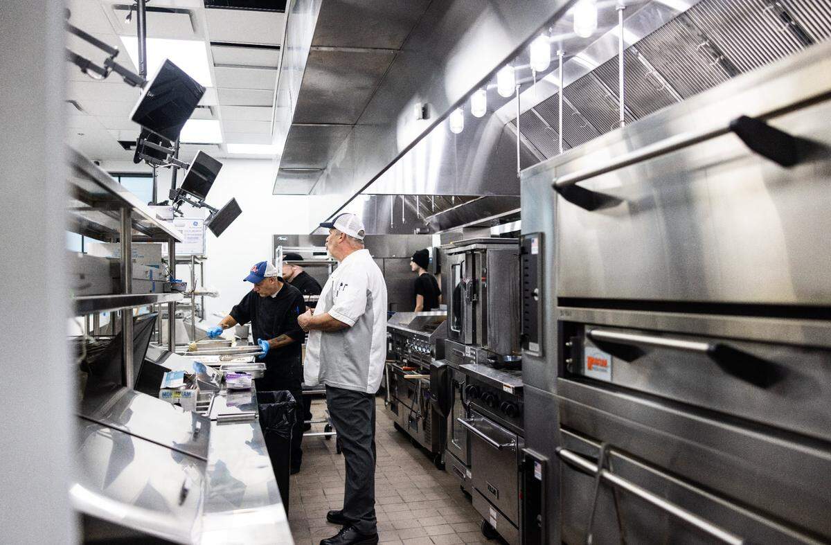 Olde Mecklenburg Brewery kitchen staff work Wednesday, May 15, 2024, in the new Ballatyne location in Charlotte that will have easy access to the food pickup window for the beer garden.