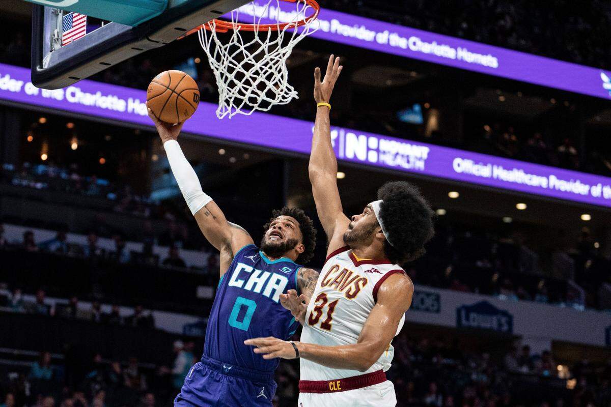 Charlotte Hornets forward Miles Bridges (0) drives to the basket while guarded by Cleveland Cavaliers center Jarrett Allen (31) during the first half of an NBA basketball game in Charlotte, N.C., Friday, Feb. 4, 2022. (AP Photo/Jacob Kupferman)