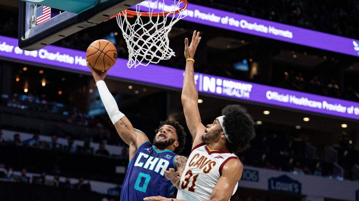 Charlotte Hornets forward Miles Bridges (0) drives to the basket while guarded by Cleveland Cavaliers center Jarrett Allen (31) during the first half of an NBA basketball game in Charlotte, N.C., Friday, Feb. 4, 2022. (AP Photo/Jacob Kupferman)