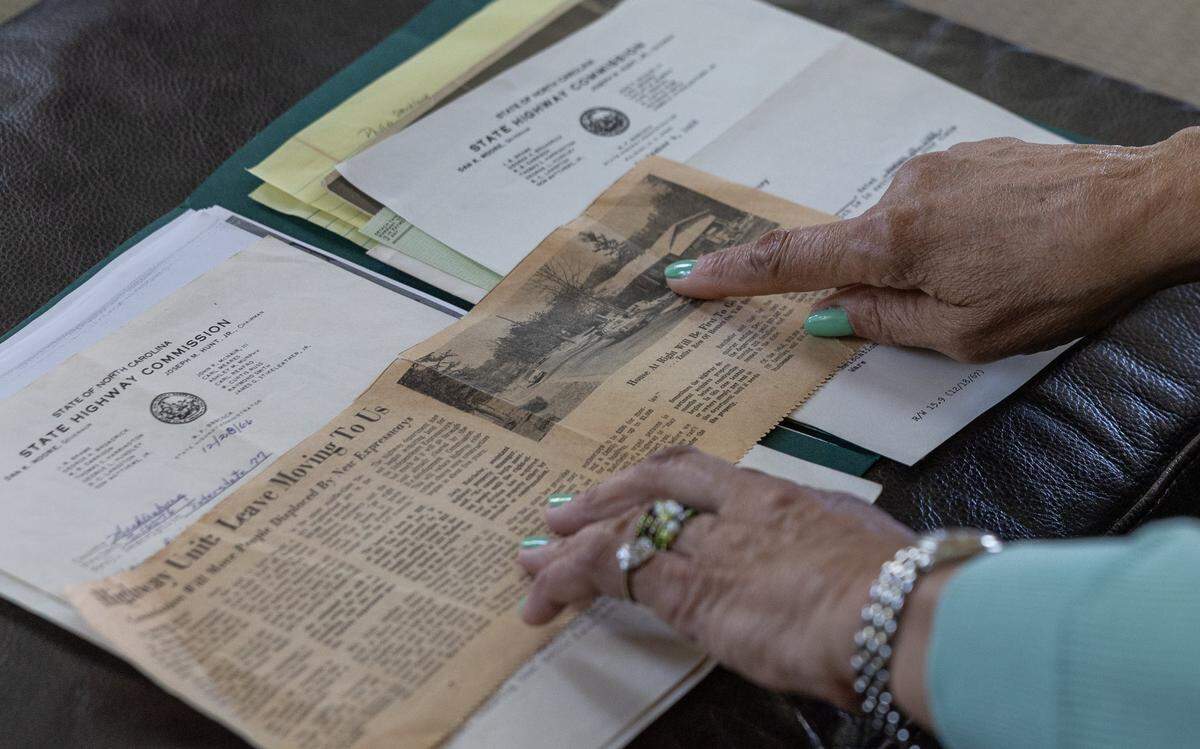 Darnell Ivory looks through documents and newspaper clippings from when her and her family were displaced by I-77 back in 1966 in Charlotte, N.C., on Friday, April 10, 2026. 