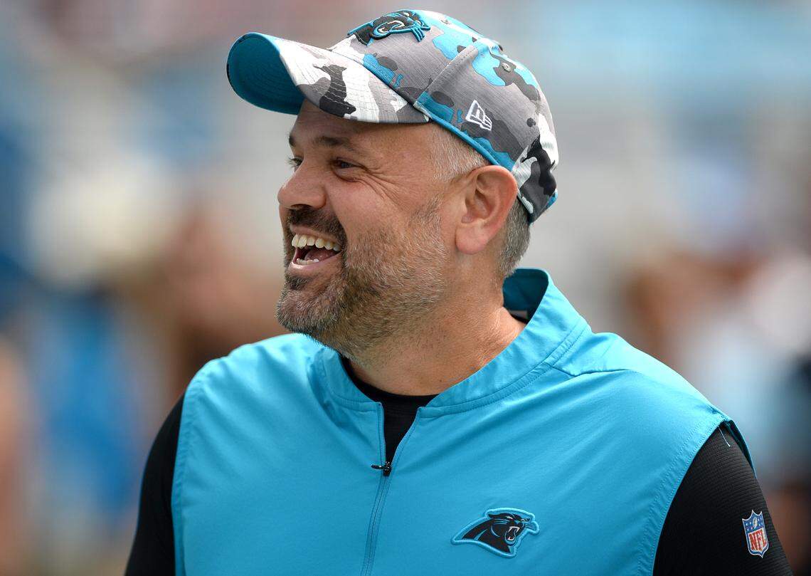 Carolina Panthers head coach Matt Rhule smiles as he greets people along the sideline prior to the team’s season opener against Cleveland on Sept. 11.