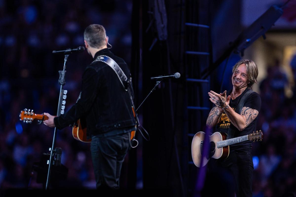 Eric Church, left, sings “Happy Birthday” to Keith Urban during Concert for Carolina at Bank of America Stadium in Charlotte on Saturday, Oct. 26, 2024.