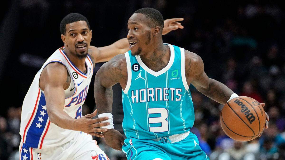 Charlotte Hornets guard Terry Rozier (3) dribbles around Philadelphia 76ers guard De’Anthony Melton, left, during the first half of an NBA basketball game Wednesday, Nov. 23, 2022, in Charlotte, N.C. (AP Photo/Rusty Jones)